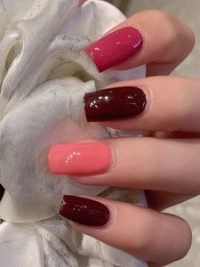 Detail of glossy red self-adhesive nail stickers in four elegant crimson shades