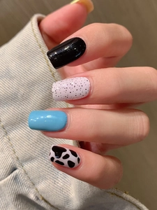 Macro detail of leopard and cow print nail stickers with blue and pink glossy finish