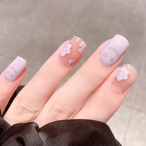 Lavender purple press-on nails with white flower patterns and cute smiley face designs