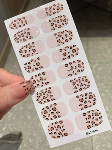 Macro detail of French leopard print nail wraps in light brown and nude tones