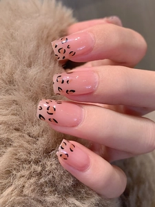Close-up of leopard print nail wraps in translucent pink on soft faux fur background