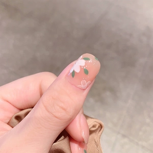 Unghie finte rosa nude con delicati fiori bianchi e foglie verdi dipinti a mano