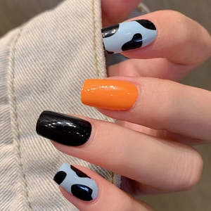 Short square press-on nails featuring blue cow print, vibrant orange, and black glossy finish