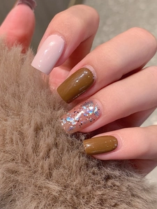Close-up of brown glitter press-on nails and glossy solid colors in square shape