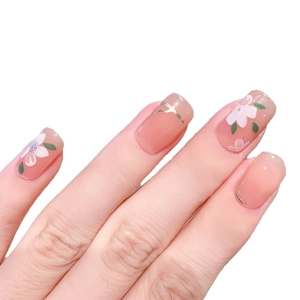 Unghie finte rosa con fiori bianchi e linee dorate presentate su una mano