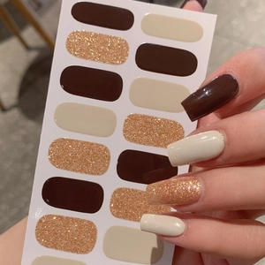 Nail art sticker set with solid dark coffee, beige, and gold glitter finishes on hands