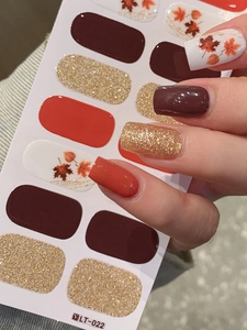 Detail showing autumn maple leaf nail stickers in orange, red and gold glitter finish
