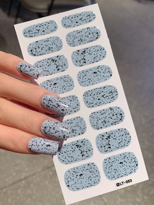 Close-up of light blue nail stickers with black eggshell spots and stone texture patterns