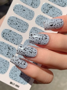 Detail of Easter egg quail texture nail stickers in light blue with black dots on model