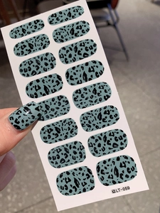 Close-up of gray leopard print nail stickers with a glossy finish and applied thumb effect