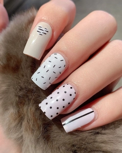 Detailed view of Valentine themed nail stickers with heart and stripe patterns on plush background