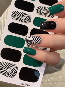 Detail of zebra pattern and dark green nail wraps set with practical application view