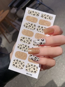Macro shot of LT-056 cream leopard print and champagne gold glitter nail art stickers