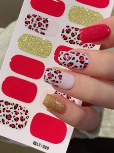 Detail view of red and leopard print nail stickers with gold glitter on white backing