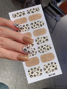 Close-up of leopard pattern nail stickers and gold glitter strips on human nails LT-056