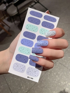 Detail of matte Easter nail wraps with speckled quail egg pattern and purple hues