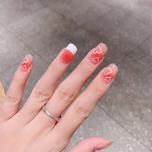 Detail of gradient blush nail stickers with heart patterns and French tips design