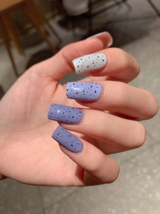 Detailed view of square nail stickers with lavender and white speckled quail egg effect