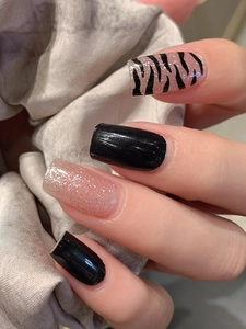 Detailed view of leopard zebra print nail stickers in black and sparkling nude pink