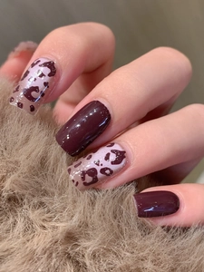 Macro shot of glossy dark purple and brown leopard print adhesive nail stickers