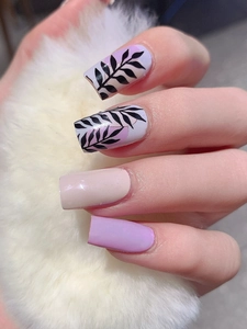 Macro shot of leaf pattern nail stickers with light purple and nude tones on square nails