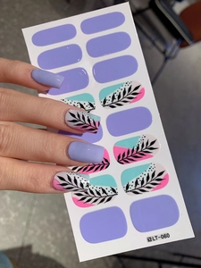 Macro shot of self-adhesive light purple nail stickers with floral patterns on a white card