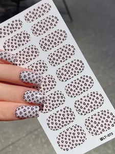 Close-up of pink heart pattern nail wraps showing natural hand-worn square oval effect