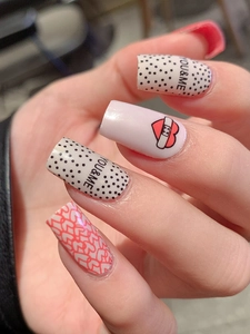 Detailed view of square press-on nails featuring red hearts, polka dots and YOU & ME text