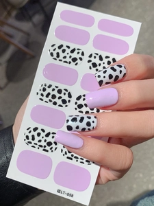 Detail of lavender and cow print nail stickers on nails with LT-058 packaging