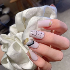 Pale pink wave pattern press-on nails with gold glitter and black ripple designs