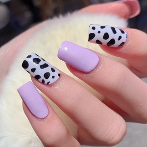 Glossy light purple and cow print nail stickers on a soft white faux fur background