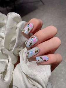 Detailed view of abstract graffiti nail wraps with gold foil on light blue base