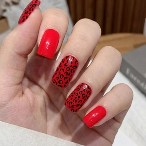 Glossy red and black leopard print press-on nails in square-round shape on hand