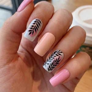 Elegant floral press-on nails in peach and pink with minimalist black leaf designs