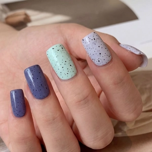 Minimalist purple and mint green press-on nails with black spotted quail egg texture
