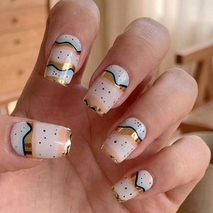 Minimalist wave geometric nail stickers with gold edges and dots on a hand