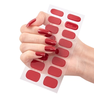 Glossy deep red gradient nail stickers set shown on transparent backing with hand model