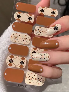 Detail of argyle pattern nail stickers in caramel and cream colors for autumn winter