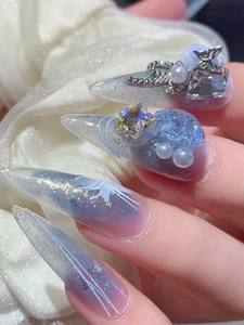 Macro view of purple gradient press-on nails with silver glitter and star charms