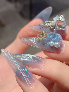 Macro detail of handmade stiletto press-on nails with purple gradient and 3D butterfly charm