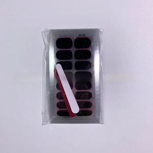 Detail of glitter black nail polish stickers with a red and white mini nail file tool