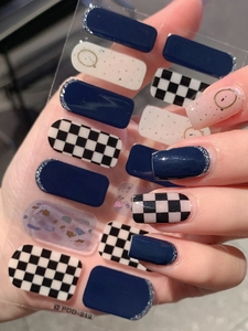Detail view of winter dark blue argyle nail stickers with silver glitter french tips