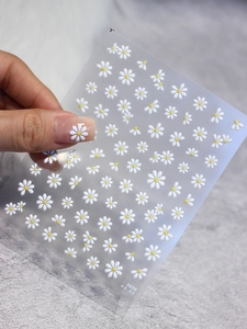 Macro shot of 3D embossed white daisy nail art stickers with jelly texture effect
