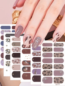 Macro detail van veelkleurige nagelstickers met luipaard- en marmerpatronen op vingers