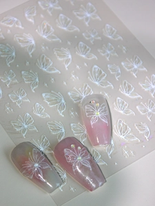 Detail of 3D embossed white butterfly nail stickers on pink gradient press-on nails