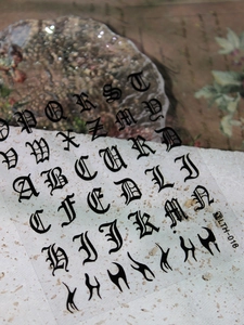 Detail of Gothic letter nail art stickers LTH-018 with black flame patterns on stone surface