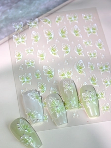Detail of 3D embossed butterfly nail stickers with mint green and white sparkling patterns
