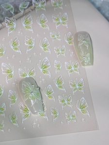 Detail of green and white butterfly nail stickers with 3D embossed pearlescent effect