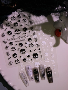Detail of Halloween nail stickers with 3D matte skulls and bones in a festive setup