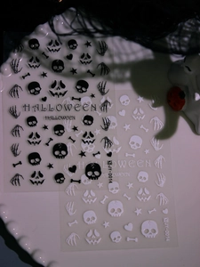 Macro detail of 3D matte Halloween nail stickers featuring skulls and pumpkins